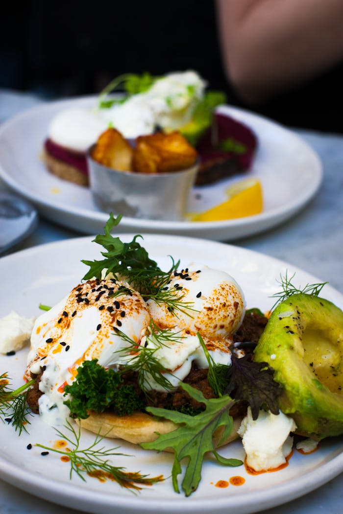 Delicious poached eggs served with avocado and fresh greens, perfect for a healthy gourmet brunch.